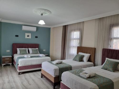 a hotel room with two beds and two chairs at Sezgin Boutique Hotel in Kusadası