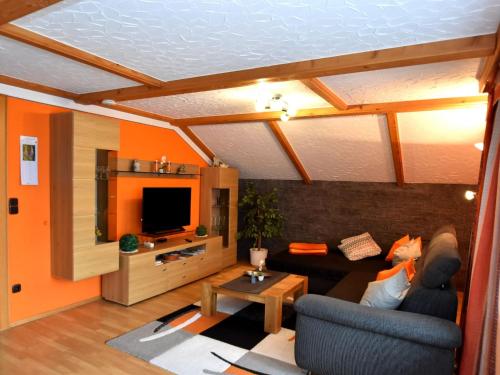 a living room with a couch and a tv at Scenic Apartment with Balcony Garden Deckchairs Barbecue in Gleißenberg