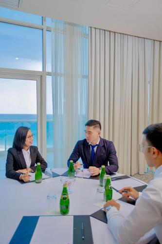 a group of people sitting around a table in a meeting at Radisson Blu Resort, Fujairah in Dibba