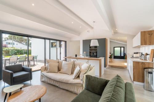 a living room with a couch and a table at Villa Stendhal - Welkeys in Seignosse