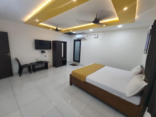 a bedroom with a bed and a table in a room at Paradise Golden Residency in Kottakupam