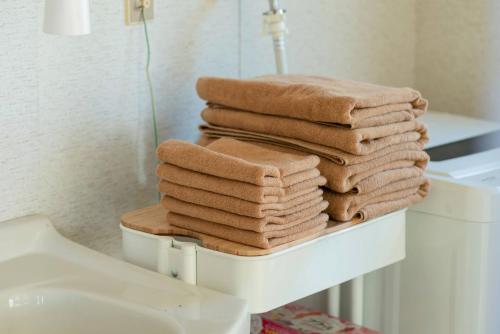 a stack of towels sitting on top of a toilet in a bathroom at VIVA SUMOTO - Vacation STAY 81374v in Amakusa