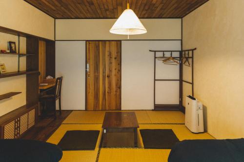 a living room with a table and a room with mats at Masukichi -hostel,cafe,souvenir,guide- in Seto