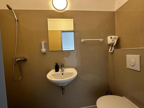 uma casa de banho com um lavatório, um WC e um espelho. em Ootel.com em Berlim