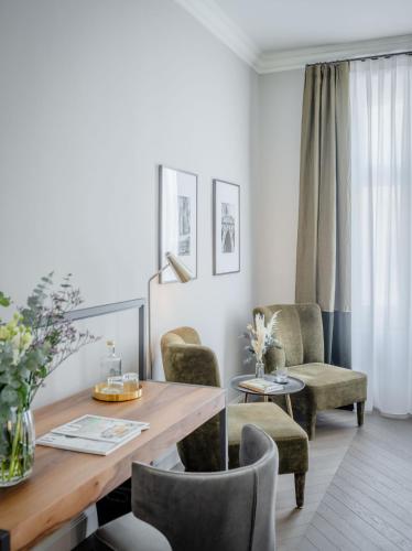 a living room with a dining room table and chairs at Roosevelt Stadthaus in Vienna