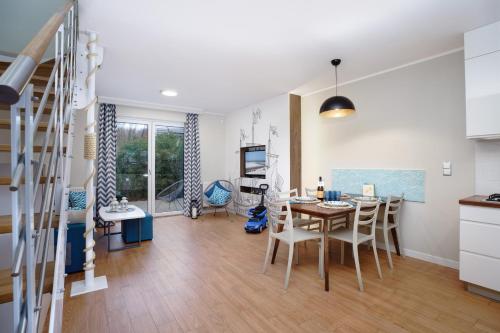 a kitchen and dining room with a table and chairs at Apartamenty, Domki i Pokoje ze śniadaniem Kajan in Jastrzębia Góra