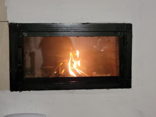 a fire in a fireplace in a room at Casa Izvorul Rece in Cîmpeni