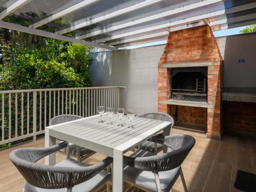 une table et des chaises sur une terrasse avec une cheminée dans l'établissement Formosa Bay, à Plettenberg Bay