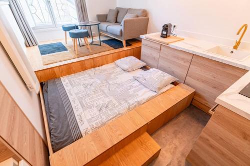 une petite maison avec un lit au milieu d'une cuisine dans l'établissement Le Boléro - Climatisation - Wifi - Hyper Centre, à Bordeaux