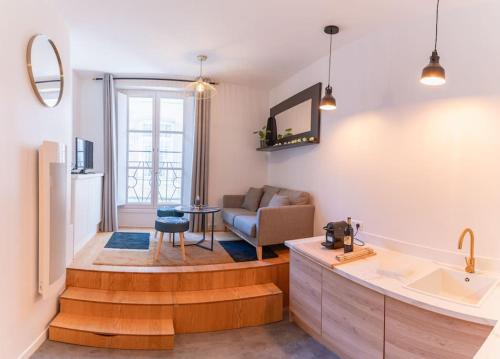 une salle de bain avec lavabo et un salon dans l'établissement Le Boléro - Climatisation - Wifi - Hyper Centre, à Bordeaux