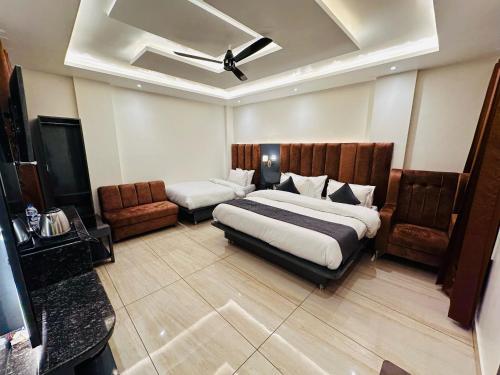 a hotel room with a bed and a couch and a bed at Hotel The Vaishvik in Katra