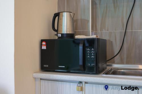 a microwave sitting on top of a kitchen counter at AnyLodge Waterfront Marina Island Pangkor in Lumut