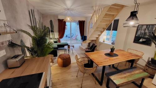 a living room with a wooden table and a staircase at Home Antonin & Maye in Tonnerre