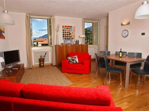 a living room with a red couch and a table at La Piazza Menaggio in Menaggio