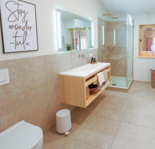 uma casa de banho com um lavatório, um chuveiro e um WC. em Amrai Appartements - Ferienwohnungen in Kreuth am Tegernsee em Kreuth