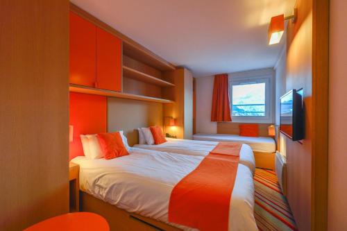 a hotel room with a bed and a tv at Villages Clubs du Soleil - LES 2 ALPES in Les Deux Alpes