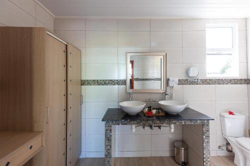 a bathroom with two sinks and a mirror at Chez Marston in La Digue