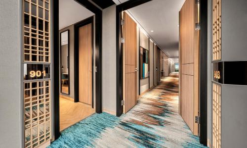 a hallway with wooden doors and a blue rug at Hyatt Place Makassar in Makassar