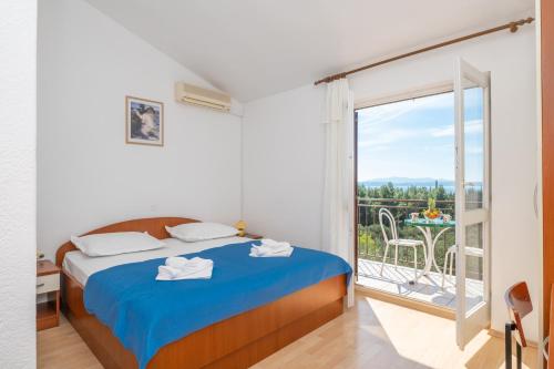 a bedroom with a bed and a large window at Rooms Olive and Sea in Tučepi