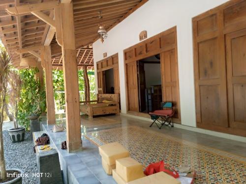 sala de estar con puertas de madera y mesa en Omah Ndoro SugihArti, en Serut