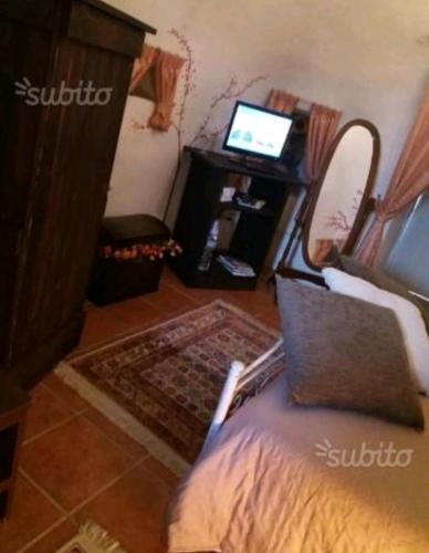a room with a bed and a desk with a laptop at Trullo Salento in Galatone
