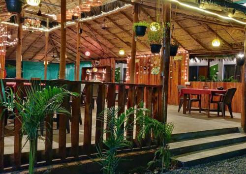 un restaurante con una valla de madera y una mesa en Yogitree Beach Resort & Cafe, en Morjim