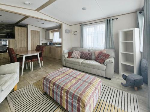 ein Wohnzimmer mit einem Sofa und einem Tisch in der Unterkunft Hot Tub Lodge in the Cotswolds - Pet Friendly in South Cerney