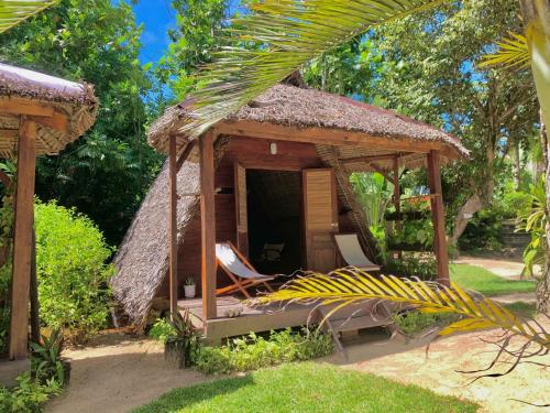 a shack with a hammock and a thatch roof at Aurora Lodge in Ile aux Nattes