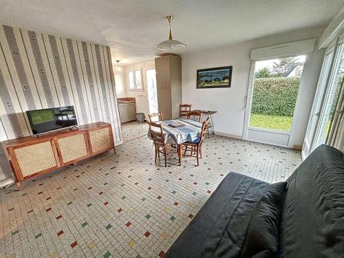 un salon avec une table, des chaises et une télévision dans l'établissement Maison de vacances avec jardin clos à 150m de la plage, idéale pour familles - FR-1-361-389, à Saint-Pair-sur-Mer