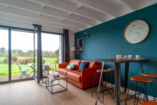 un salon avec un canapé rouge et une table dans l'établissement La Terrasse du Golf - Appt avec terrasse, à Bénodet