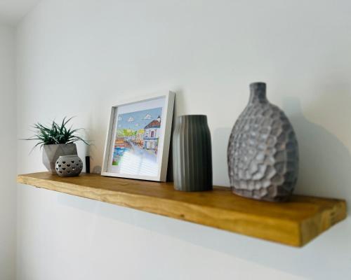 a shelf with a picture and vases on it at Historic 'Old Toll House' Shaldon Bridge in Teignmouth