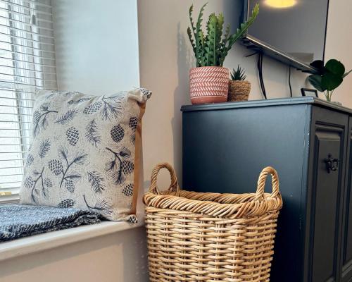a wicker basket sitting on a window sill next to a pillow at Historic 'Old Toll House' Shaldon Bridge in Teignmouth