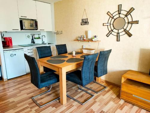 een eettafel met blauwe stoelen en een keuken bij Ferienwohnung Wallner Rosi in Sankt Englmar