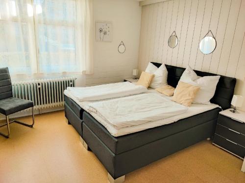 a bedroom with a large bed and a chair at Ferienwohnung Wallner Rosi in Sankt Englmar