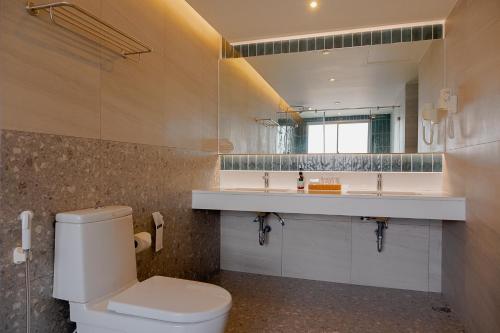 a bathroom with a toilet and a sink and a mirror at Buri Sriphu Hotel in Hat Yai