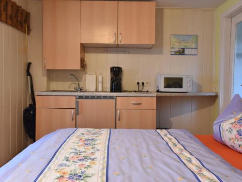 a small kitchen with a bed and a microwave at Cozy apartment in Boltenhagen Germany near the beach in Boltenhagen