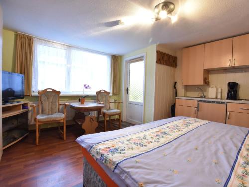 ein Schlafzimmer mit einem Bett und einem Tisch sowie eine Küche in der Unterkunft Cozy apartment in Boltenhagen Germany near the beach in Boltenhagen