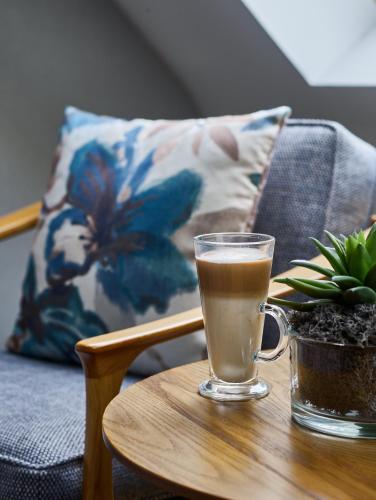 a glass of coffee sitting on a wooden table at Fairlawns, Hotel And Spa in Walsall