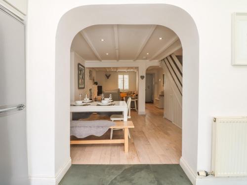 uma sala de jantar com um arco e uma mesa branca em Riversdale Cottage em Wadebridge