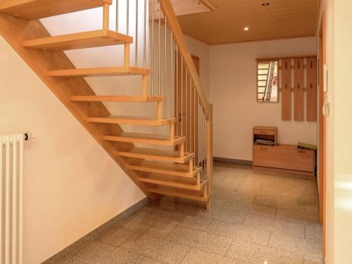 a wooden staircase in a room with a hallway at Cosy farmhouse apartment at the edge of the forest in Mühlenbach