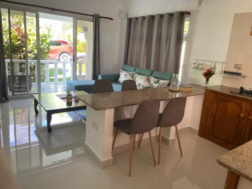 a kitchen and living room with a table and chairs at MARL Self Catering in Pointe Larue