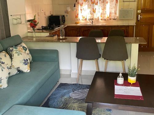 a living room with a couch and a kitchen at MARL Self Catering in Pointe Larue