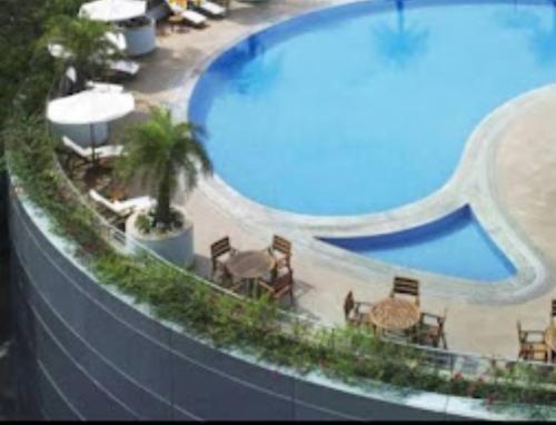 a view of a swimming pool with tables and chairs at Hotel Grand Resort 2 Puri Sea View Room - Swimming Pool - Lift Facilities - Best Seller in Puri