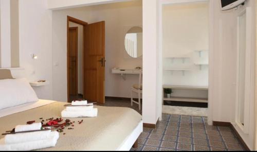 een slaapkamer met een bed met handdoeken en een spiegel bij B&B I 3 Mori in Barcellona-Pozzo di Gotto