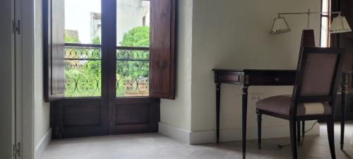 コルドバにあるPalacio de los Angulo casa histórica en el centro de Córdobaのドア、デスク、窓が備わる客室です。