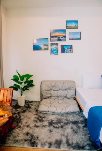 a bedroom with a bed and a couch and pictures on the wall at Thuyền Xưa Homestay Đảo Phú Quý in Cu Lao Thu
