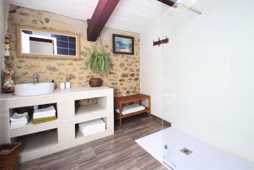 ein Bad mit einem Waschbecken und einem Spiegel in der Unterkunft Ancienne maison en pierre au coeur du village in Usclas-lʼHérault