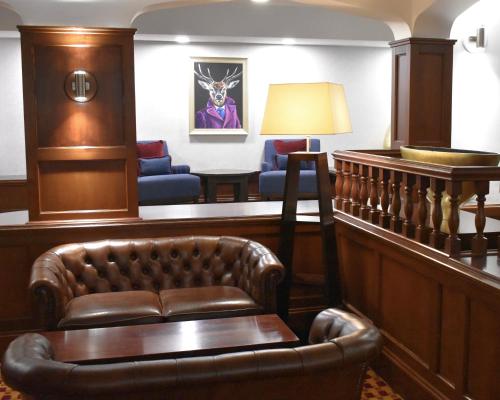 a waiting room with a couch and a lamp at The Aberdeen Dyce Hotel in Dyce