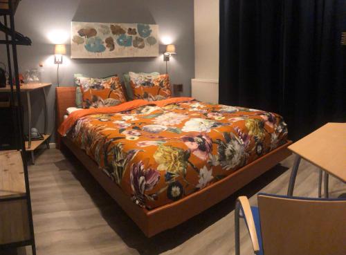 Un dormitorio con una cama grande con una manta naranja en SEA MORE, en Zandvoort