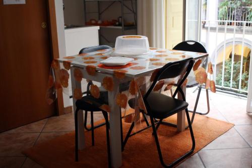 ナポリにあるB&B ナポリ プレビスチオのキッチンテーブル(椅子、ケーキ付)